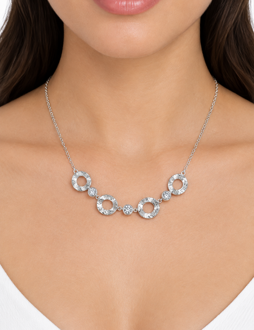 Collana argentata indossata su sfondo bianco