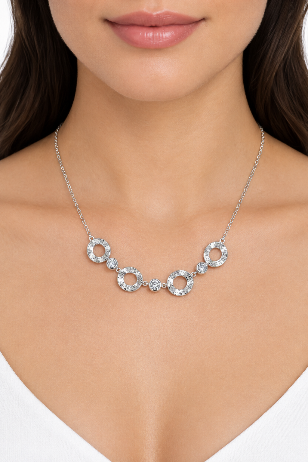 Collana argentata indossata su sfondo bianco