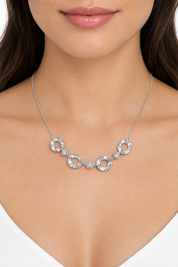 Collana argentata indossata su sfondo bianco