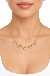 Collana dorata indossata su sfondo bianco