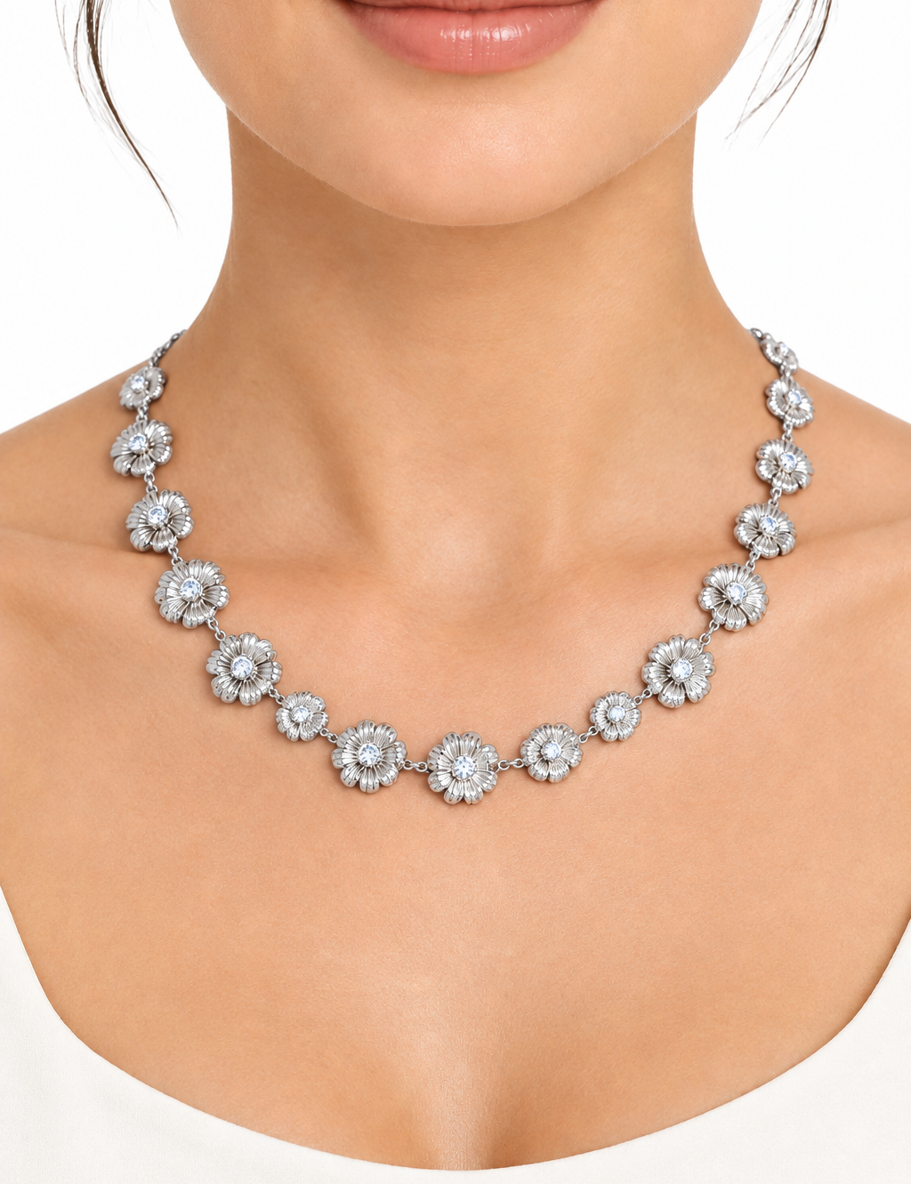 Collana floreale color argento indossata su sfondo bianco